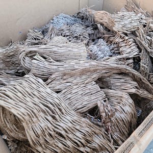 May include: A cardboard box filled with crumpled brown packing paper. The paper is used for protecting fragile items during shipping.