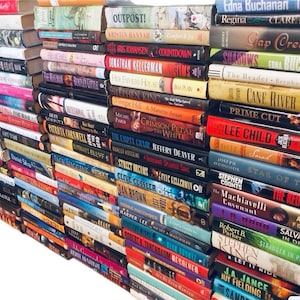 May include: A wall of books stacked vertically, with titles visible on the spines. The books are a mix of genres, including fiction, mystery, and thriller. Some of the titles include "Outpost!", "The Crimson Petal and the White", "Prime Cut", "Lee Child", "Midnight Line", "Star of the Sea", "The Red Horseman", "Salvation in Death", and "Stranger in Paradise".
