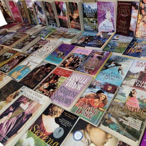 Peut inclure: Une grande collection de romans d'amour en format poche avec diff&eacute;rents titres et auteurs. Les livres sont empil&eacute;s en rang&eacute;es et en colonnes, cr&eacute;ant un affichage color&eacute; et visuellement attrayant.