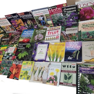 May include: A collection of gardening books with colorful covers featuring various plants, flowers, and gardening tools. The titles include "Gardening with Clematis", "Vegetable Gardening", "Down-to-Earth Vegetable Gardening Know-How", "The New Seed Starters Handbook", and "Vegetable Gardening Pacific Northwest".