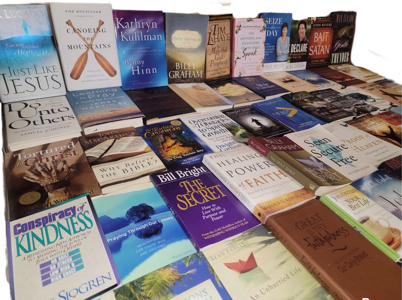 May include: A collection of various books with religious themes, including titles such as "Just Like Jesus", "Tortured Christ", "The Healing Power of Faith", and "Seen Secure Free".