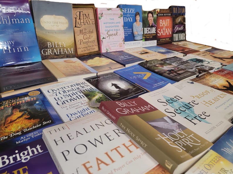 May include: A collection of various Christian books and novels stacked on top of each other. The books have different titles and authors, including "Seize the Day", "Bait and Declare Satan", "The Mothers and Daughters of the Bible Speak", "Unto the Hills", "Merciful God Prophecy", "Overcoming 7 Obstacles to Spiritual Growth", "The Healing Power of Faith", "The Holy Spirit", "Seen Secure Free", "Proof of Heaven", and "Billy Graham".