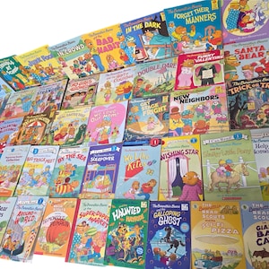May include: A collection of children's books featuring the Berenstain Bears. The books have colorful covers with illustrations of bears in various scenarios. Titles include "Forget Their Manners," "Trick or Treat," and "The Big Track Meet."