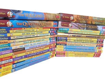 May include: A stack of children's books by G. Stilton and Thea Stilton, featuring titles like "The Volcano of Fire," "The Quest for Paradise," and "The Kingdom of Fantasy." The books have colorful covers with illustrations.