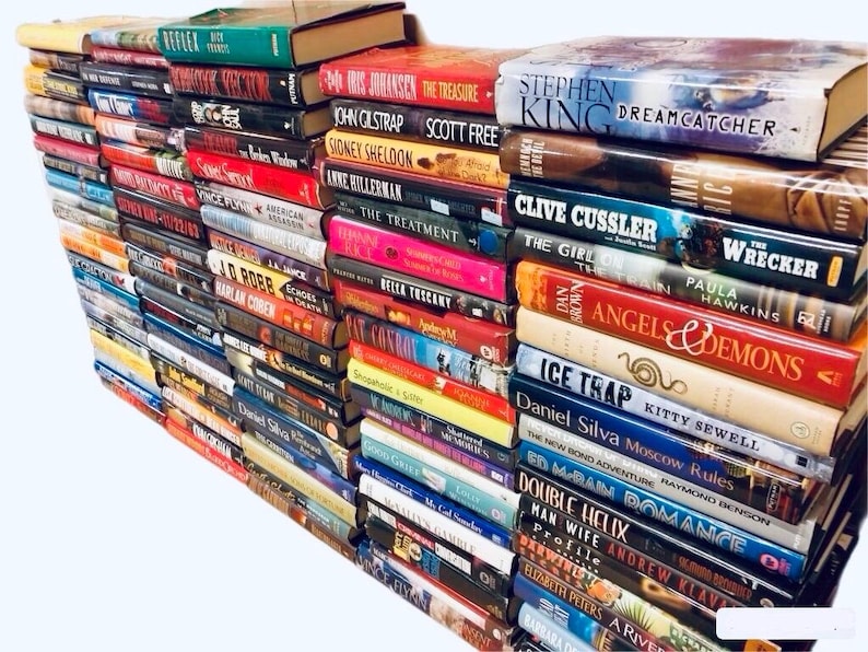 May include: A large stack of paperback books, mostly fiction, with various titles and authors visible. The books are arranged in a vertical stack, with the spines facing outward. The books are a mix of colors, including red, blue, green, and black.