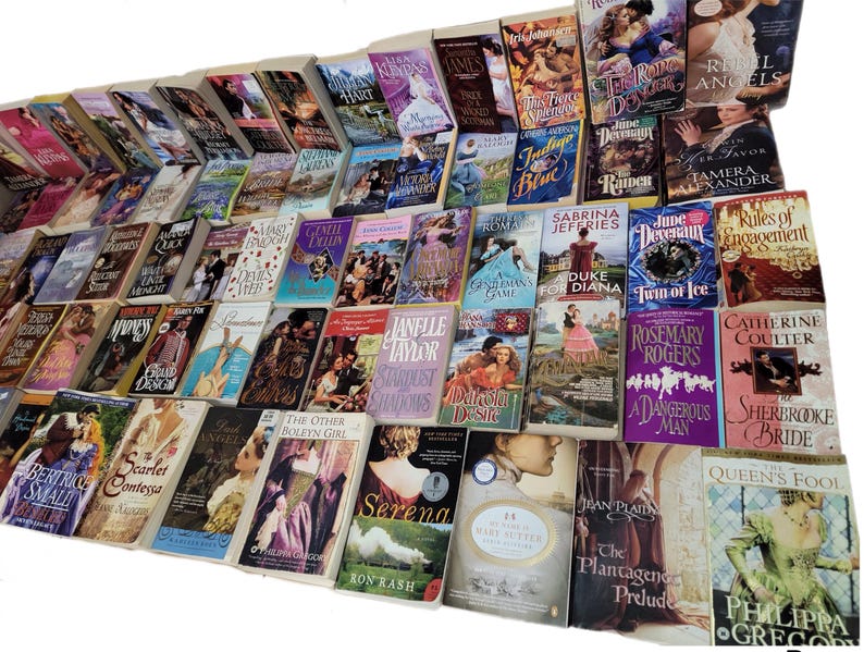 Peut inclure: Une grande collection de romans d'amour en format poche avec diff&eacute;rents titres et auteurs. Les livres sont dispos&eacute;s en rang&eacute;es et pr&eacute;sentent une vari&eacute;t&eacute; de couvertures avec des couleurs et des motifs diff&eacute;rents.