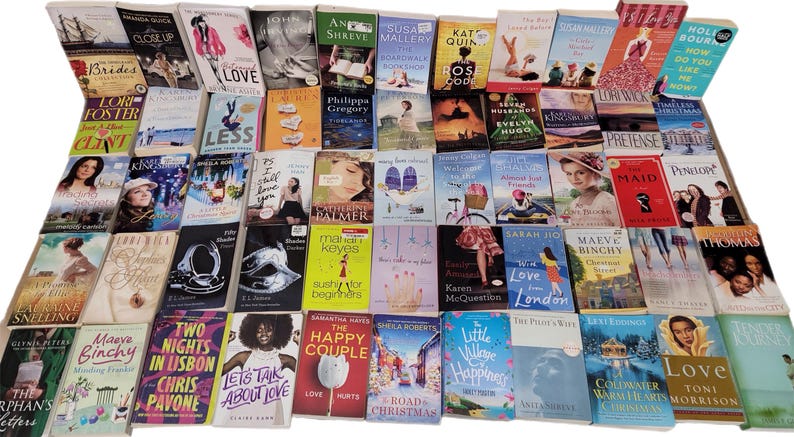 May include: A collection of paperback books with various titles and authors. The books are arranged in rows and columns on a surface. The books are mostly romance novels with colorful covers.