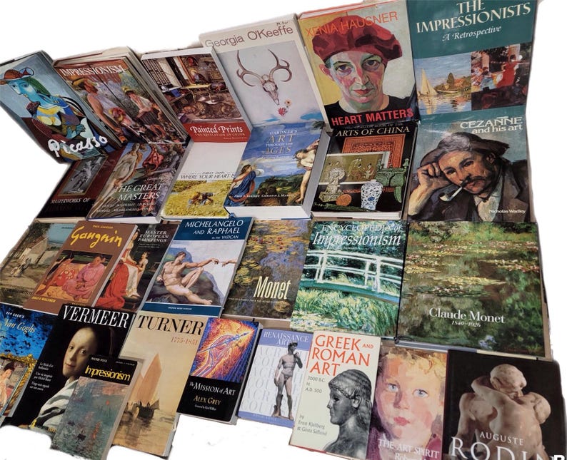 May include: A collection of art books featuring various artists and art movements, including Impressionism, Cezanne, Monet, and Michelangelo. The books are arranged in a pile on a surface.