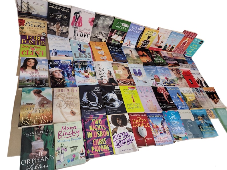 May include: A collection of paperback books with various titles and authors. The books are stacked in a pile, with the spines facing out. The books are mostly romance novels, with some other genres mixed in.