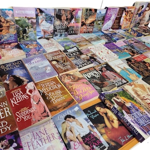 Peut inclure: Une grande collection de romans d'amour avec diff&eacute;rents titres et auteurs. Les livres sont empil&eacute;s en rang&eacute;es et sont principalement en format poche.