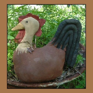 May include: A brown and black fabric chicken with a red comb and a black tail. The chicken is sitting on a brown metal planter.