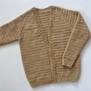 Op de afbeelding: Een beige gebreide cardigan met een V-hals en lange mouwen.