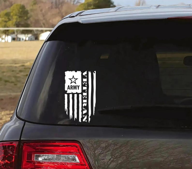 K&ouml;nnte beinhalten: Ein wei&szlig;er Vinyl-Aufkleber mit einer amerikanischen Flagge und den Worten "Veteran Army" darauf. Der Aufkleber befindet sich auf der Heckscheibe eines schwarzen Autos.