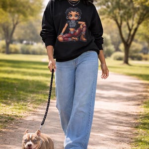 A woman wearing a black sweatshirt with a graphic of a cartoon character and the text "Original Boop". Betty Boop crewneck sweatshirt