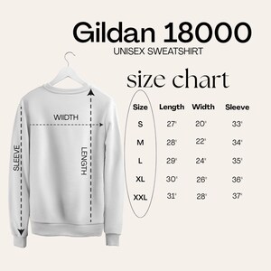 May include: A Gildan 18000 unisex sweatshirt size chart displaying a white sweatshirt on a hanger with dashed lines indicating length, width, and sleeve measurements. A table lists sizes S through XXL with corresponding dimensions in inches.