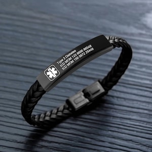 Op de afbeelding: Zwart leren armband met een roestvrijstalen medische ID-tag. De tag heeft een ster-van-leven-symbool en de tekst "Type 2 Diabetes ICD MOM 123 6666 86548 ICD MOM 159 5872 25449".