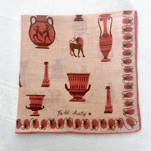 May include: A pink linen handkerchief with a red border and a repeating pattern of red Greek urns, columns, and a lion. The handkerchief is signed "Faith Austin."
