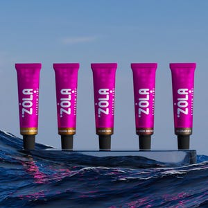 May include: Five tubes of eyebrow tint in different shades: light brown, warm brown, brown, dark brown, and graphite. The tubes are pink with black caps and the brand name "ZOLA" is printed in white.