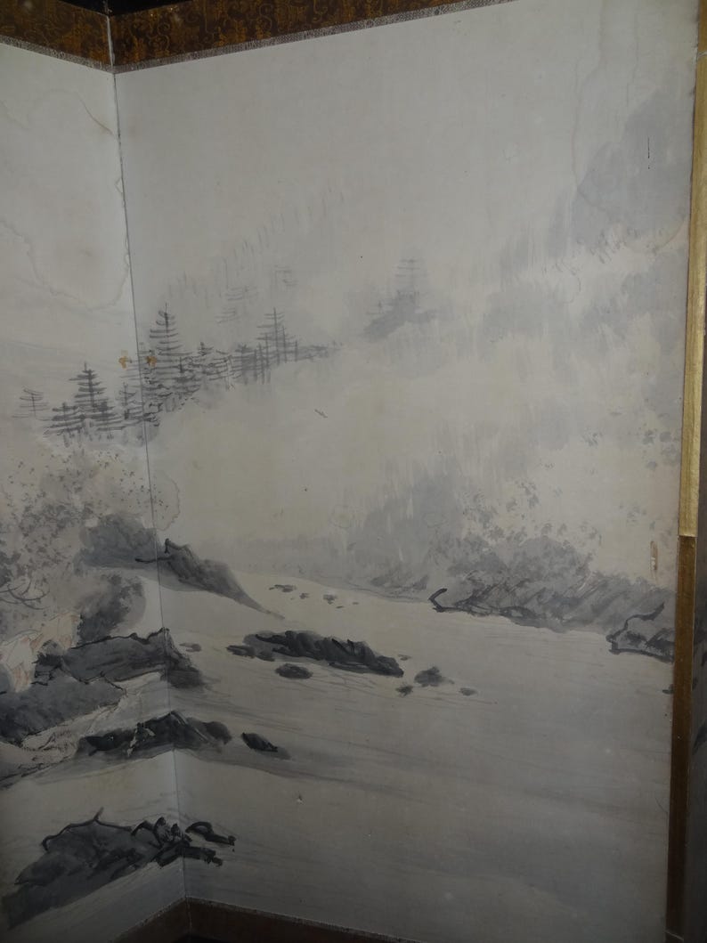 May include: A corner wall mural featuring a landscape scene in shades of gray and white. The artwork depicts a mountainous terrain with trees and water, creating a serene and naturalistic aesthetic. The mural is framed with a gold border.