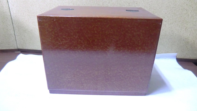 May include: A brown wooden box with a textured surface.