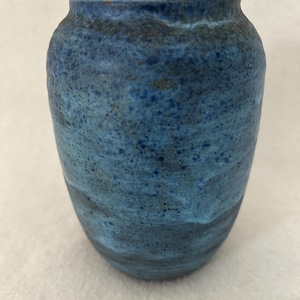 May include: A set of three ceramic mugs with a speckled, matte finish. The mugs are in shades of cream, light gray, and dark gray. Each mug has a simple, minimalist design and a rounded handle.