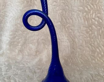 Può includere: Un vaso in vetro blu cobalto con un collo attorcigliato e curvo e una base svasata. Il vaso è in vetro spesso e ha una finitura liscia e lucida.