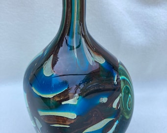 May include: A blue, brown, and white glass vase with a swirl design. The vase has a narrow neck and a wide, rounded base.