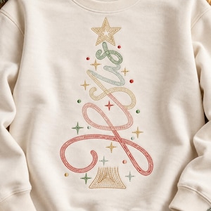 Könnte beinhalten: Ein cremefarbenes Sweatshirt mit Rundhalsausschnitt und einer Stickerei, die einen Weihnachtsbaum darstellt. Dieser besteht aus einer durchgehenden geschwungenen Linie in rotem, grünem und goldenem Garn, gekrönt von einem Stern und kleinen Stern- und Punktmotiven.