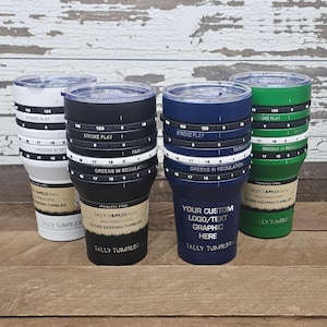 May include: Four stainless steel golf score keeping tumblers in white, black, navy blue, and green. Each tumbler has a clear lid and a rotating ring for tracking scores. The navy blue tumbler has space for custom graphics.