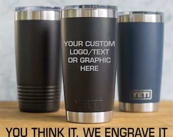 May include: Three stainless steel tumblers with lids. The center black tumbler features the engraved text: YOUR CUSTOM LOGO/TEXT OR GRAPHIC HERE. The text below reads: YOU THINK IT, WE ENGRAVE IT. IMAGES PREFERRED: EPS, PDF, AI, JPEG.