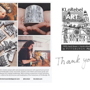May include: Black and white illustrations of Pittsburgh landmarks printed on coasters and a cylindrical container. The artist is working on a coaster in the image. The text "KLoRebel ART 100% hand drawn + handcrafted in PITTSBURGH, PA Thank you!" is also included in the image.