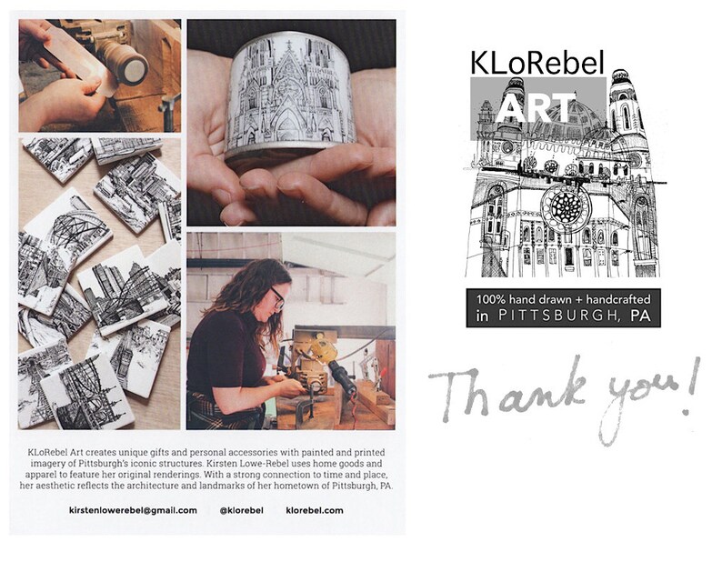 May include: Black and white illustrations of Pittsburgh landmarks printed on coasters and a cylindrical container. The artist is working on a coaster in the image. The text "KLoRebel ART 100% hand drawn + handcrafted in PITTSBURGH, PA Thank you!" is also included in the image.