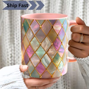 Peut inclure: Une tasse en céramique rose avec un motif géométrique de carrés irisés et d'accents dorés. La tasse a un intérieur et une anse roses. Le texte "Ship Fast" est affiché en haut à gauche de la tasse.