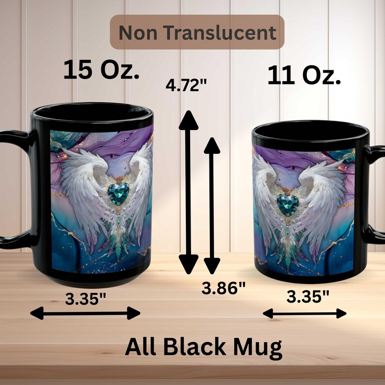 Op de afbeelding: Twee zwarte mokken met een wit gevleugeld engelontwerp en een teal hart. De mokken zijn gelabeld met 15 oz. en 11 oz. met afmetingen van 12 cm en 9.8 cm hoog en 8.5 cm breed. De tekst "Non Translucent" en "All Black Mug" zijn ook zichtbaar.