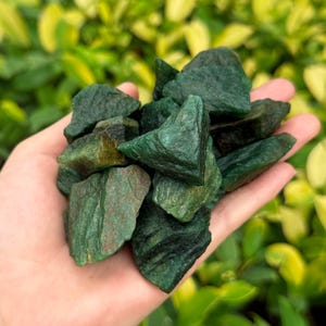 May include: A collection of green aventurine crystal chips. The chips are rough and have a natural, earthy look.