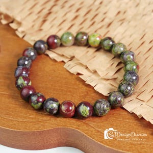 Dragon Blood Stone Elastic Bracelet Flat Lay Image, Strung with 8mm Polished Beads, Featuring Intense Green Base with Red Vein Pattern.