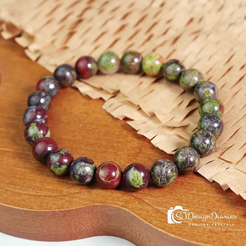 Dragon Blood Stone Elastic Bracelet Flat Lay Image, Strung with 8mm Polished Beads, Featuring Intense Green Base with Red Vein Pattern.