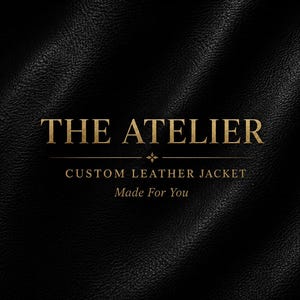 May include: A black leather background with a textured surface featuring gold text that reads THE ATELIER, CUSTOM LEATHER JACKET, and Made For You, centred with a small decorative star symbol between the lines of text.