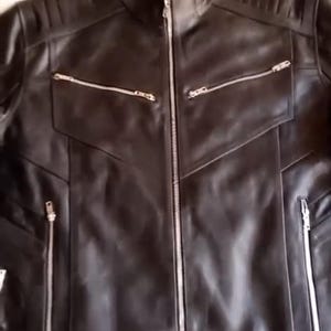 May include: Black leather jacket with a stand-up collar and multiple zipped pockets. The jacket features a front zip closure and quilted shoulder detailing. A classic outerwear piece.