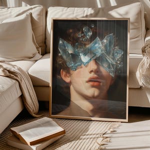 Puede incluir: Una pintura enmarcada de un rostro con fragmentos de vidrio azul que cubren sus ojos. La pintura está en un estilo oscuro y melancólico.