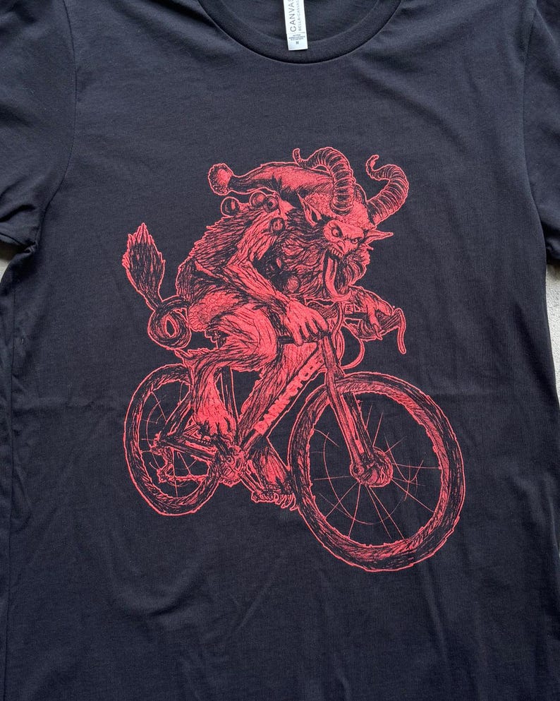 Pode incluir: Uma ilustra&ccedil;&atilde;o vermelha de uma criatura com chifres e um chap&eacute;u de Papai Noel andando de bicicleta. A criatura tem uma l&iacute;ngua longa para fora. O fundo &eacute; preto.