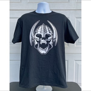Może przedstawiać: Czarny T-shirt z białym nadrukiem czaszki w rogacym hełmie.