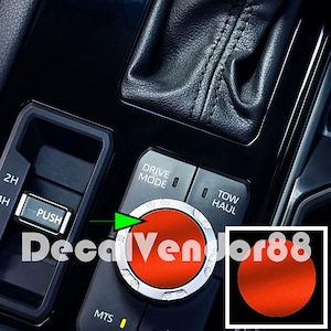 May include: Close-up of a car's interior console featuring a red dial with a silver trim. The console includes buttons labeled "DRIVE MODE" and "TOW HAUL". The text "DecalVendor88" is overlaid on the image.