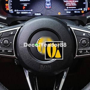 May include: A black leather steering wheel with a yellow and black decal that says "DecalVendor88".