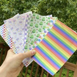 Puede incluir: Un conjunto de seis láminas de vinilo termoadhesivo con patrones. Los patrones incluyen una raya de arcoíris, un patrón de cuadros, un diseño de rana y flores, una bandera del orgullo transgénero, un patrón de corazón y un patrón blanco y azul.