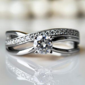 Anillo infinito con engaste dividido y banda pavé cruzada, engastado en oro blanco de 10 quilates, con moissanita de 0,5 quilates.