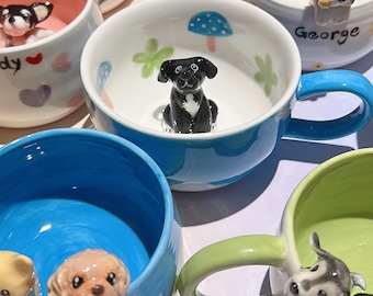 May include: A collection of colorful ceramic mugs, each adorned with a 3D dog figurine. The mugs feature various colors, including blue, pink, and green, with matching handles. Some mugs have floral and mushroom designs inside.
