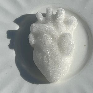 Puede incluir: Un corazón de azúcar blanco en un plato blanco.