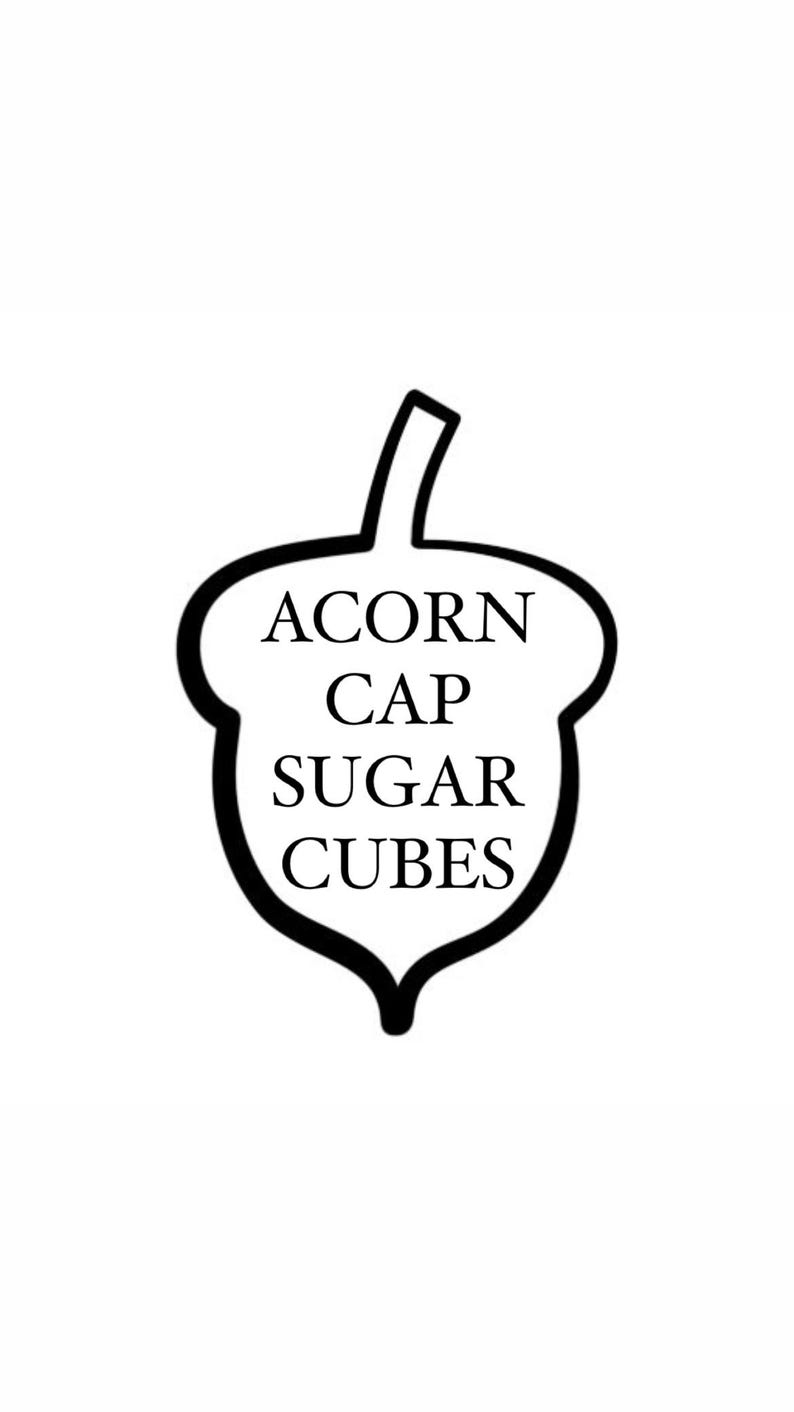 May include: Black and white illustration of an acorn with the text "ACORN CAP SUGAR CUBES" inside.