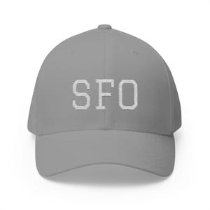 May include: A grey baseball cap featuring the embroidered letters "SFO" in white. The cap has a curved peak and a structured fit. This hat is a stylish accessory for everyday wear.